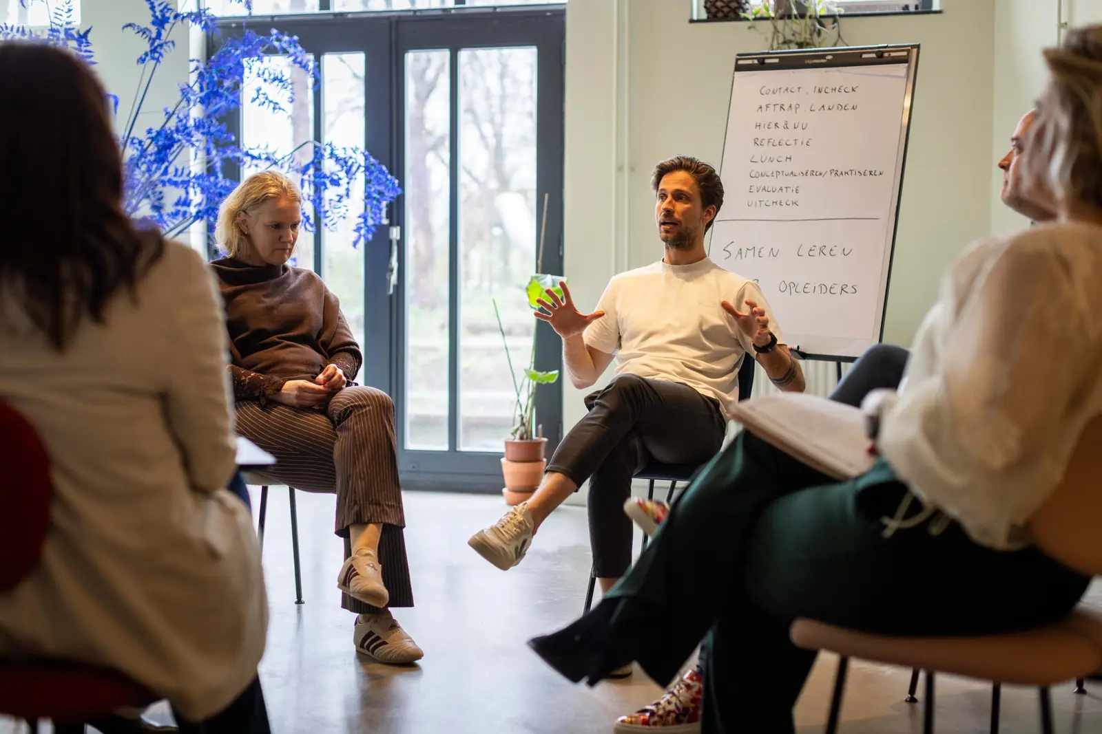 Een kring van deelnemers in gesprek tijdens een bijeenkomst van &Jonk