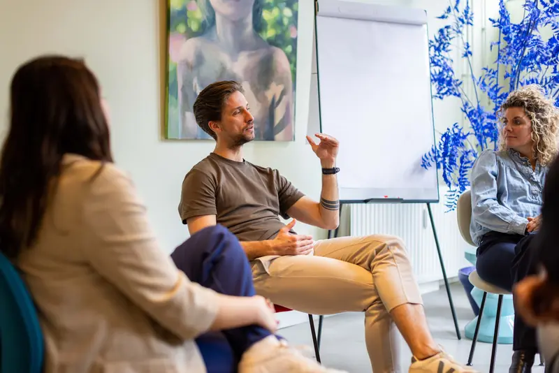 Eric Jonk in gesprek met deelnemers, zittend in een kring
